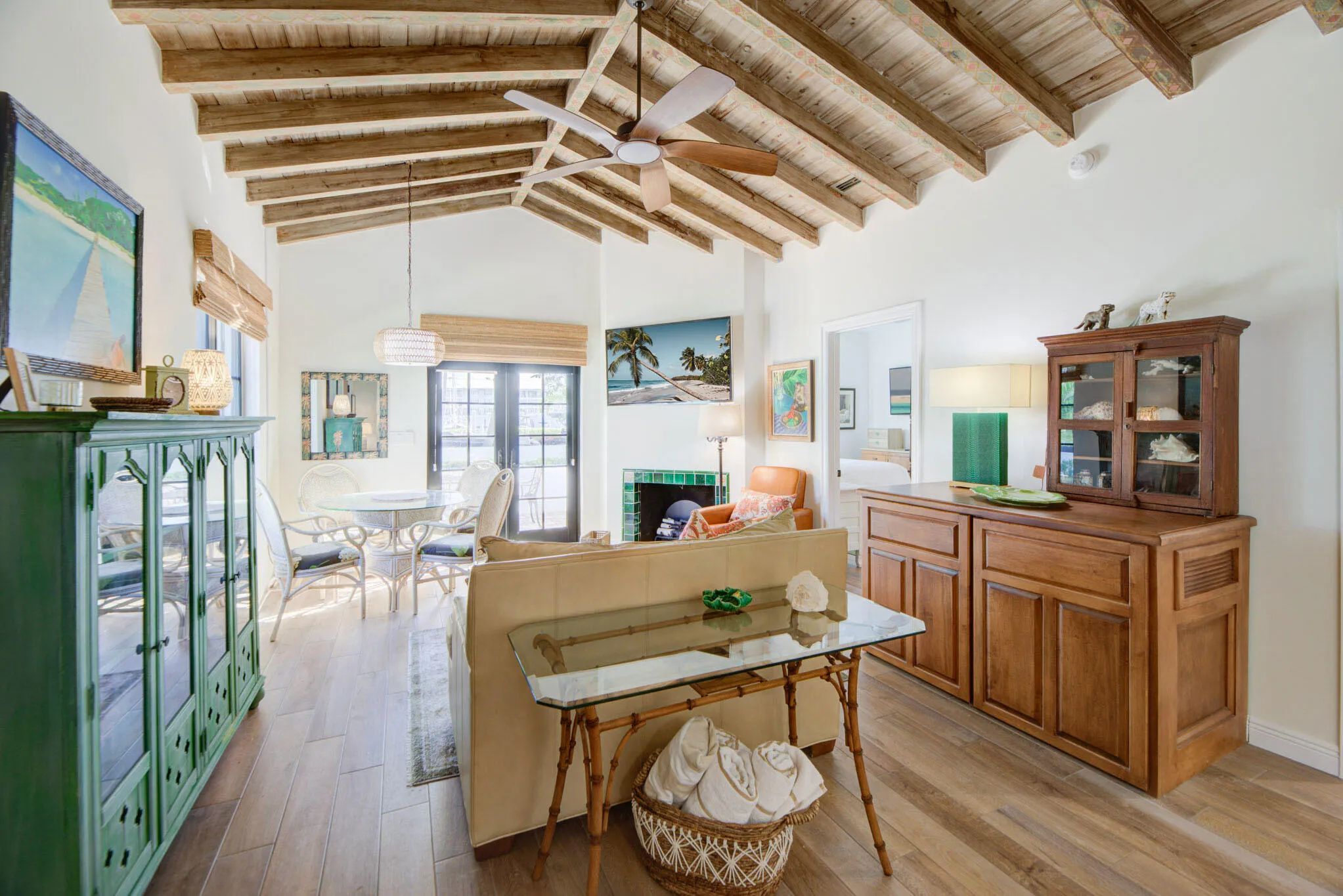 Vaulted ceiling with exposed wood beams and a ceiling fan