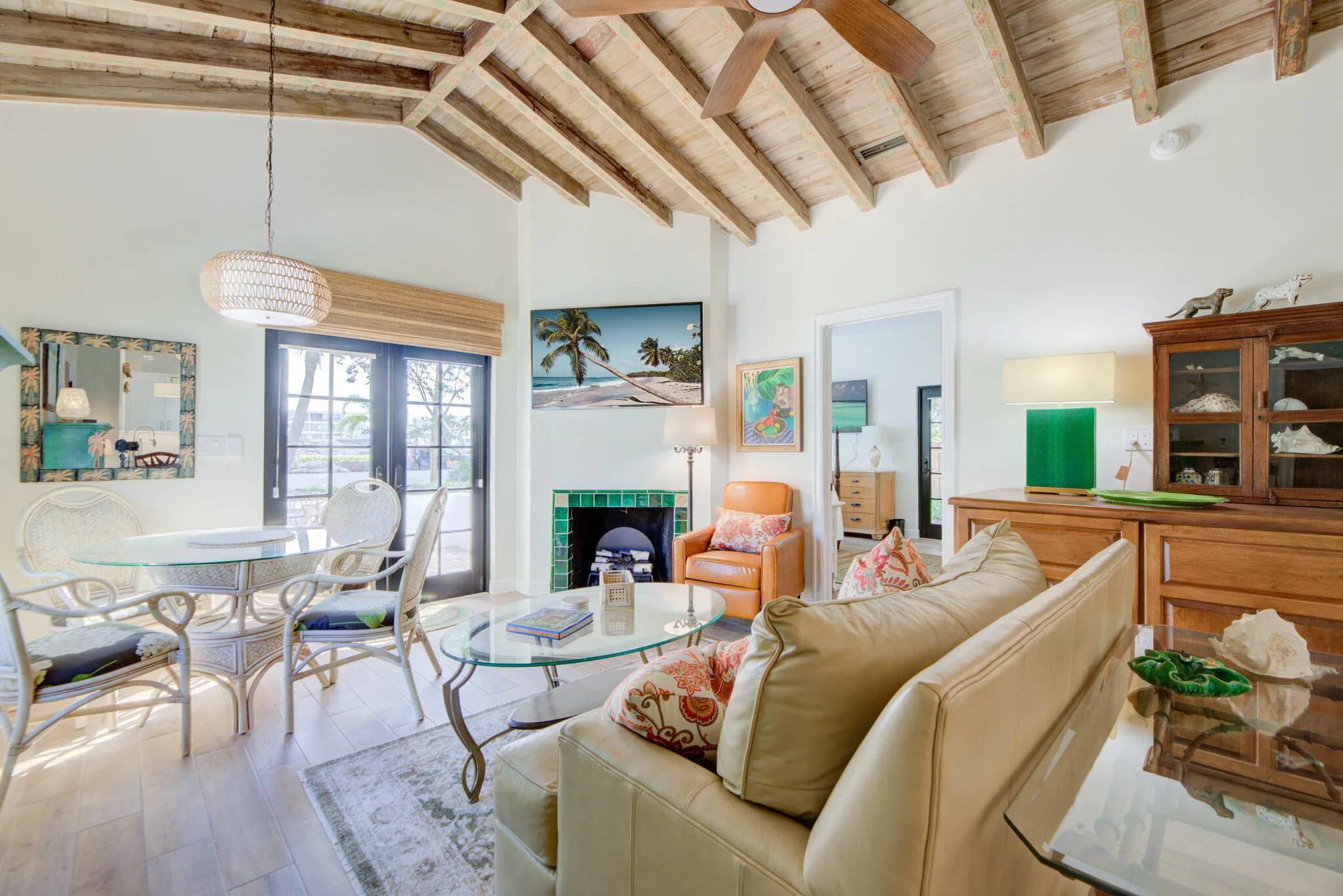 Vaulted wood-beamed ceilings complementing wood-finish flooring, also featuring an elec fireplace.