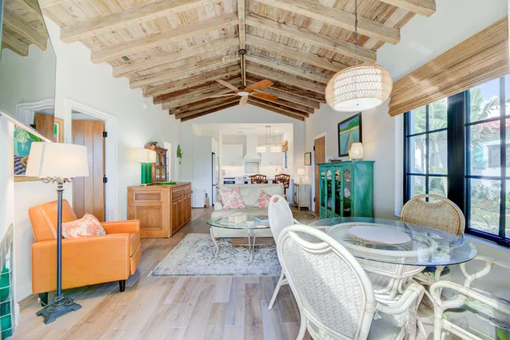 Vaulted wood-finish ceiling featuring exposed beams and a ceiling fan