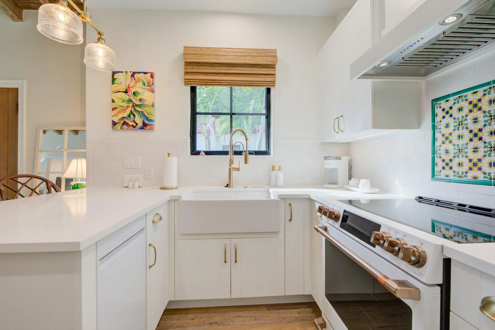 White kitchen featuring an apron front sink, brass fixtures, a built-in electric range, white cabinetry, and light countertops