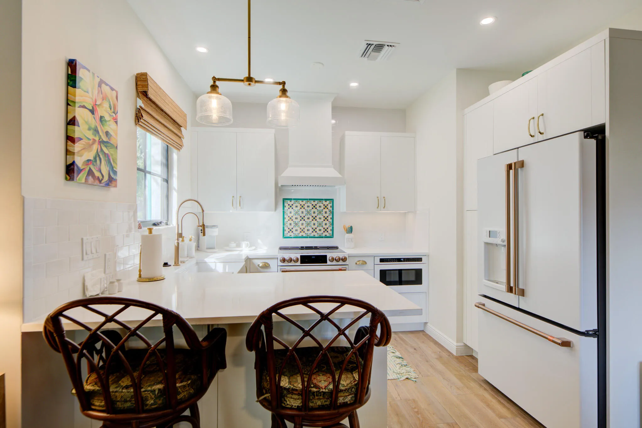 Contemporary kitchen featuring white cabinetry, light-toned wood-finish flooring, and a patterned tile backsplash