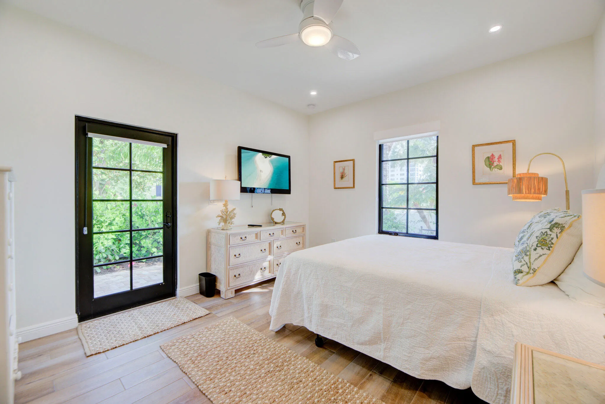 Spacious room featuring wood-finish flooring and a black-framed glass-paneled door