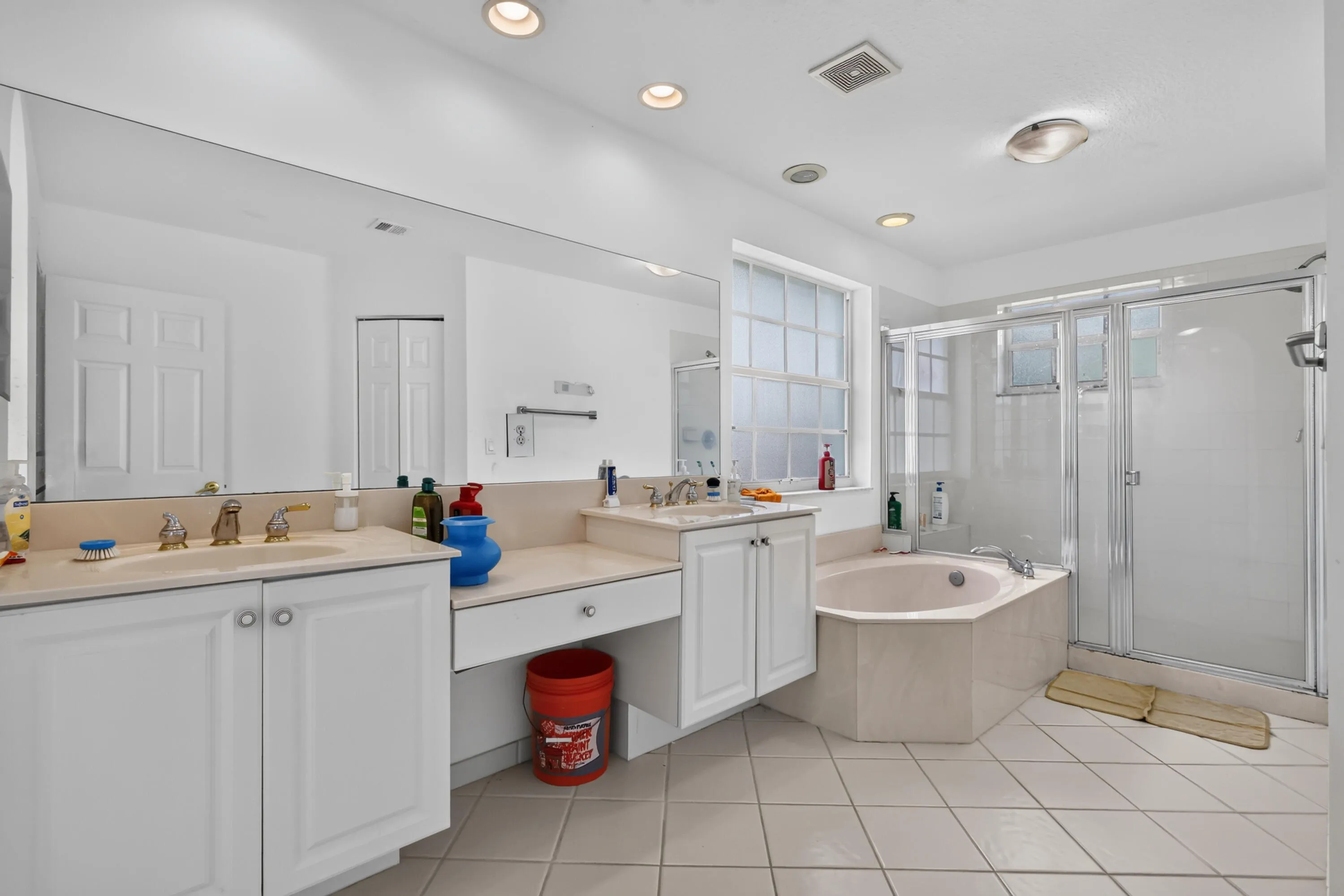 Luxurious master bathroom featuring dual vanities with ample counter space, a soaking tub, and a spacious walk-in shower with glass enclosure