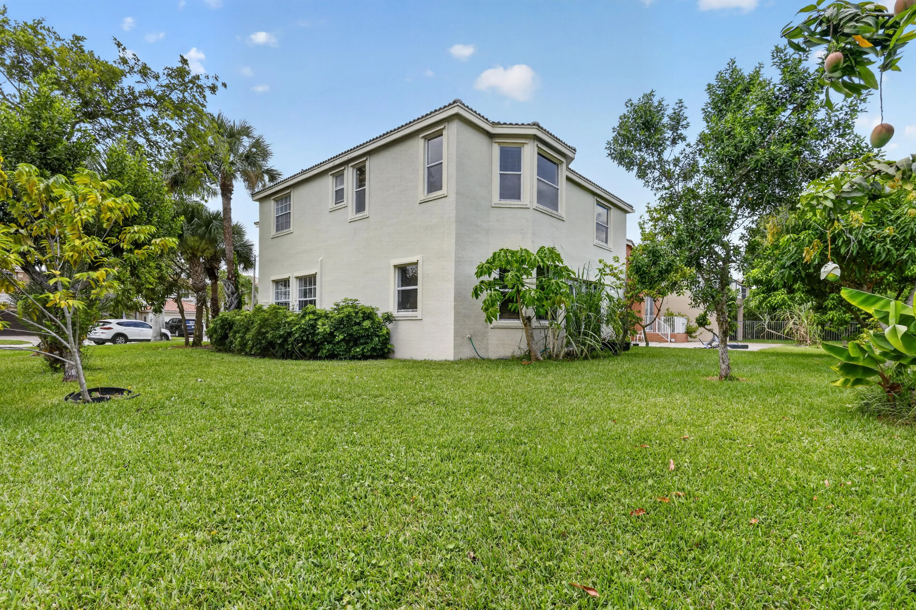 Two-story stucco exterior featuring multiple windows and a bay window on the upper level