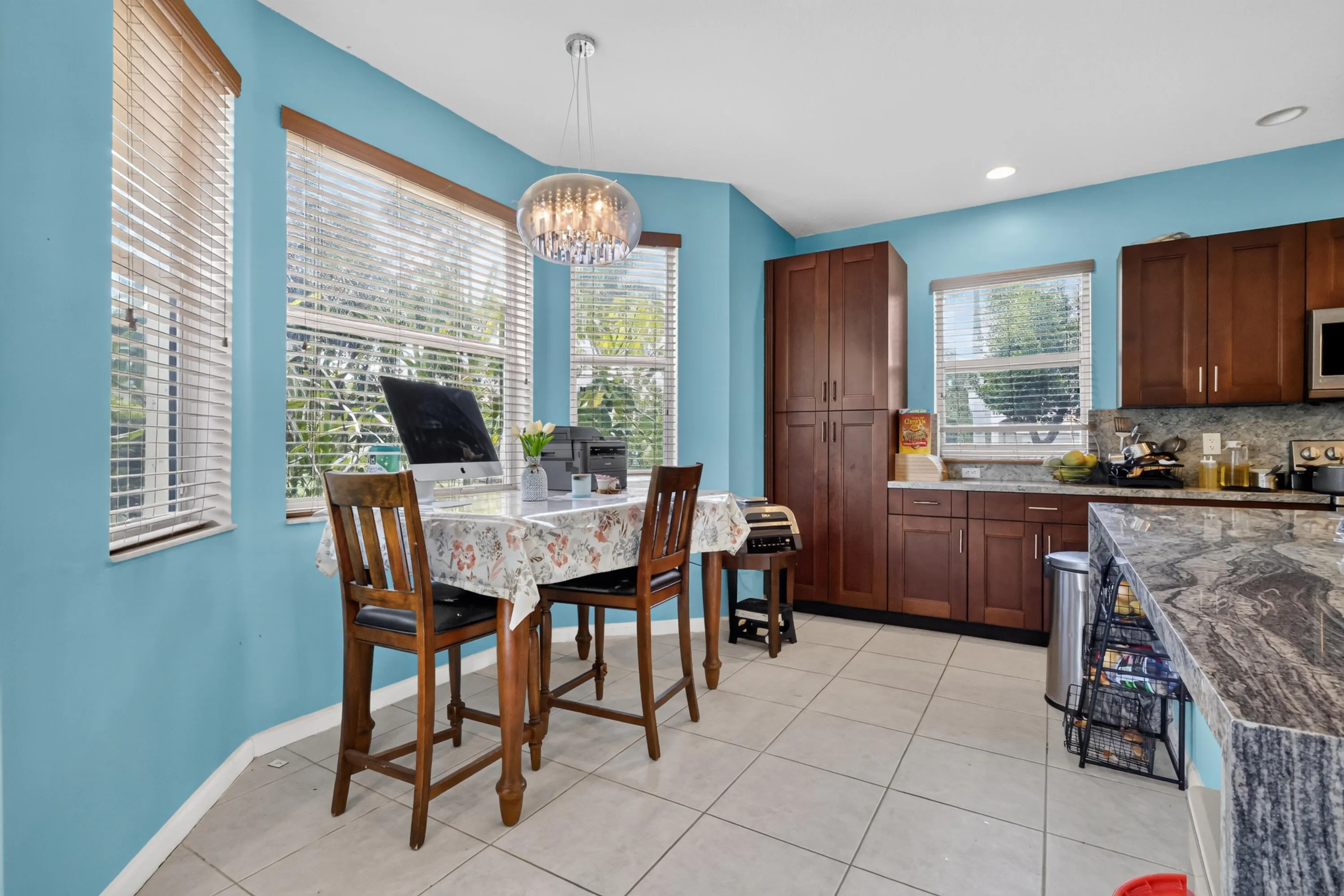 Kitchen featuring a large central island with a stone countertop, wood-finish cabinetry, and recessed lighting