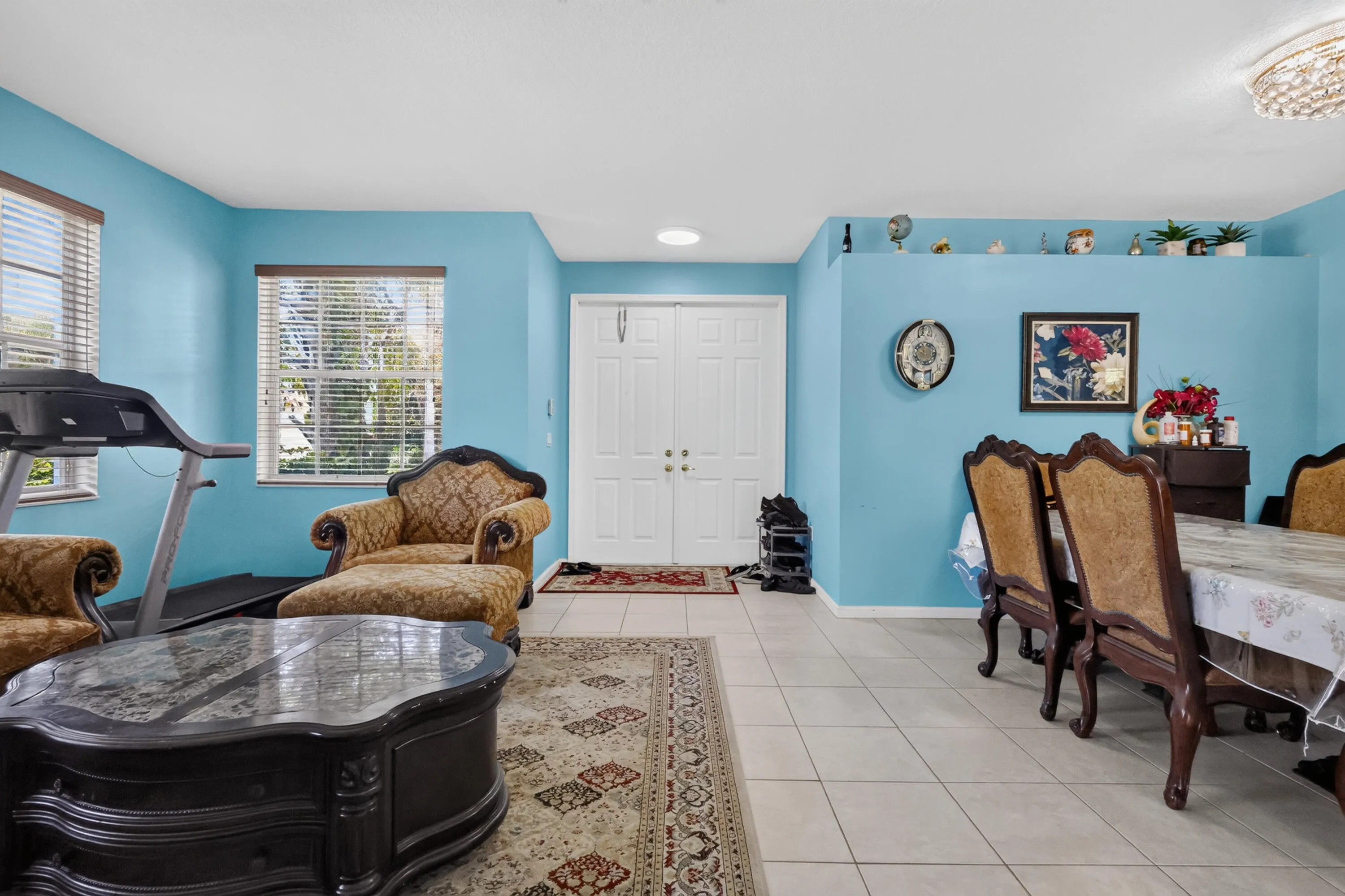 Bright interior space featuring light blue walls and large windows with blinds