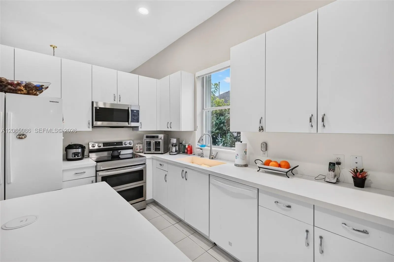 Spacious open concept kitchen w/ built in wall unit, volume ceilings and solid surface counters