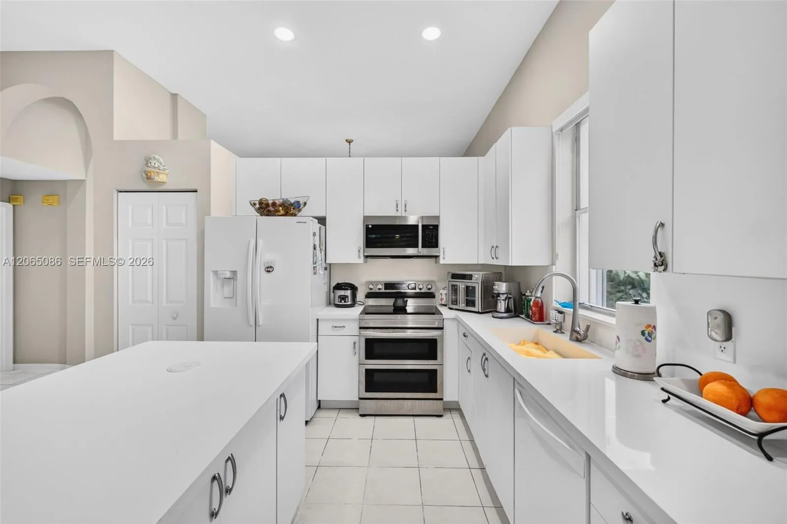 Spacious open concept kitchen w/ built in wall unit, volume ceilings and solid surface counters