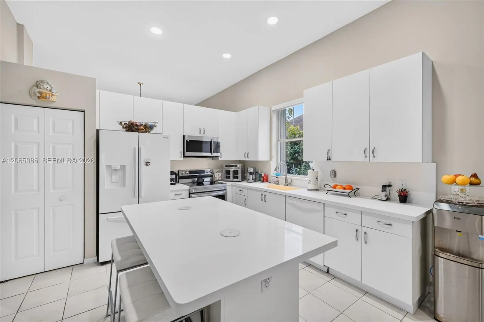Spacious open concept kitchen w/ built in wall unit, volume ceilings and solid surface counters