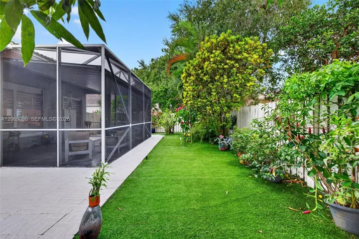 Step outside to your large, fully tiled, screened-in patio with a covered overhang overlooking a fully fenced backyard with mature fruit trees, astroturf, and a Rain Bird irrigation system.
