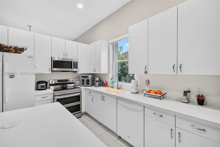 Spacious open concept kitchen w/ built in wall unit, volume ceilings and solid surface counters