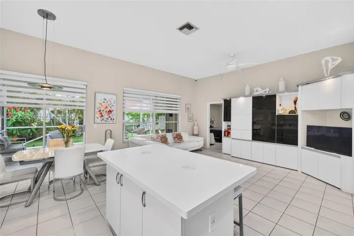 Spacious open concept kitchen w/ built in wall unit, volume ceilings and solid surface counters