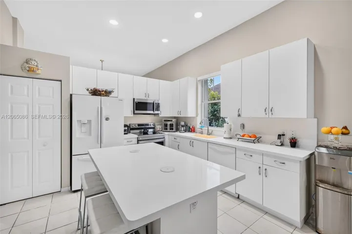 Spacious open concept kitchen w/ built in wall unit, volume ceilings and solid surface counters