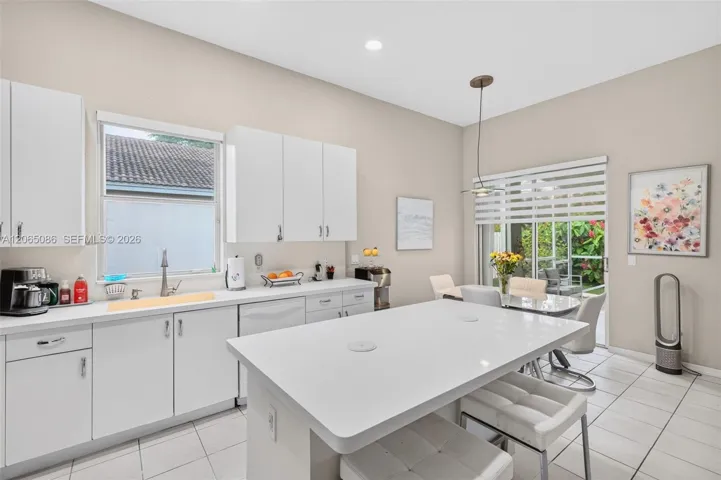 Spacious open concept kitchen w/ built in wall unit, volume ceilings and solid surface counters