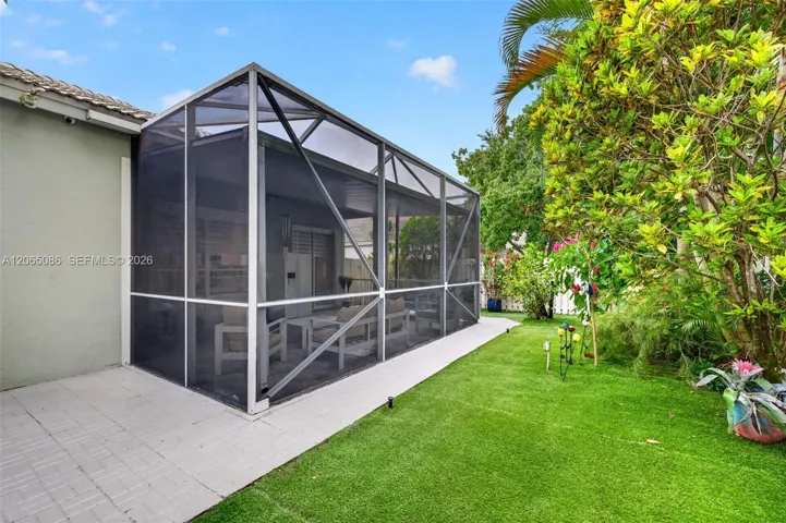 Step outside to your large, fully tiled, screened-in patio with a covered overhang overlooking a fully fenced backyard with mature fruit trees, astroturf and a Rain Bird irrigation system.