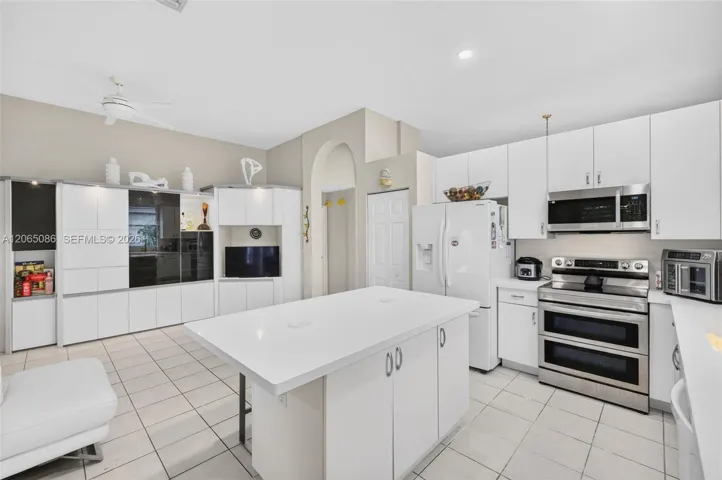 Spacious open concept kitchen w/ built in wall unit, volume ceilings and solid surface counters