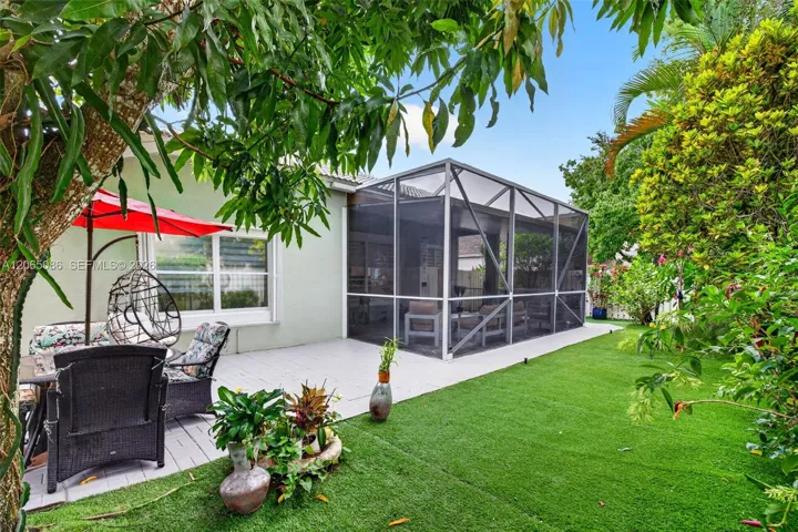 Step outside to your large, fully tiled, screened-in patio with a covered overhang overlooking a fully fenced backyard with mature fruit trees, astroturf and a Rain Bird irrigation system.