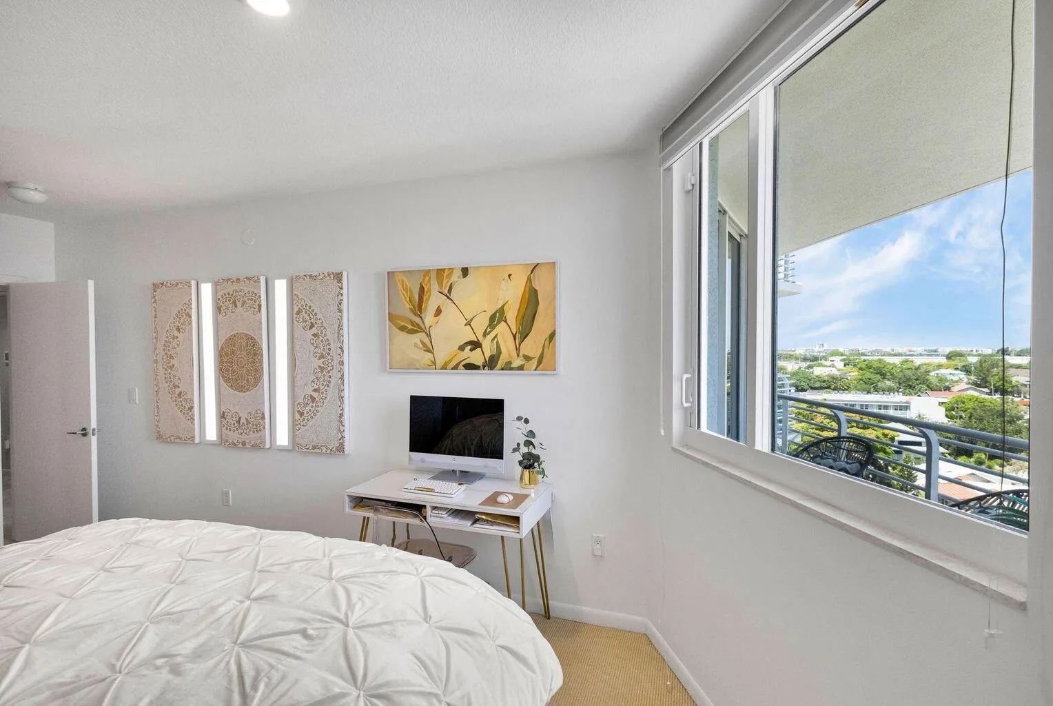 Expansive window with a partial balcony, featuring a cityscape and green canopy