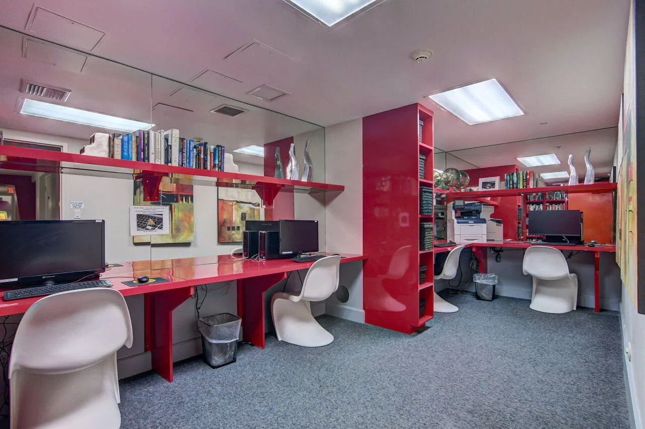 Dedicated workspace featuring vibrant red built-in desks and shelving