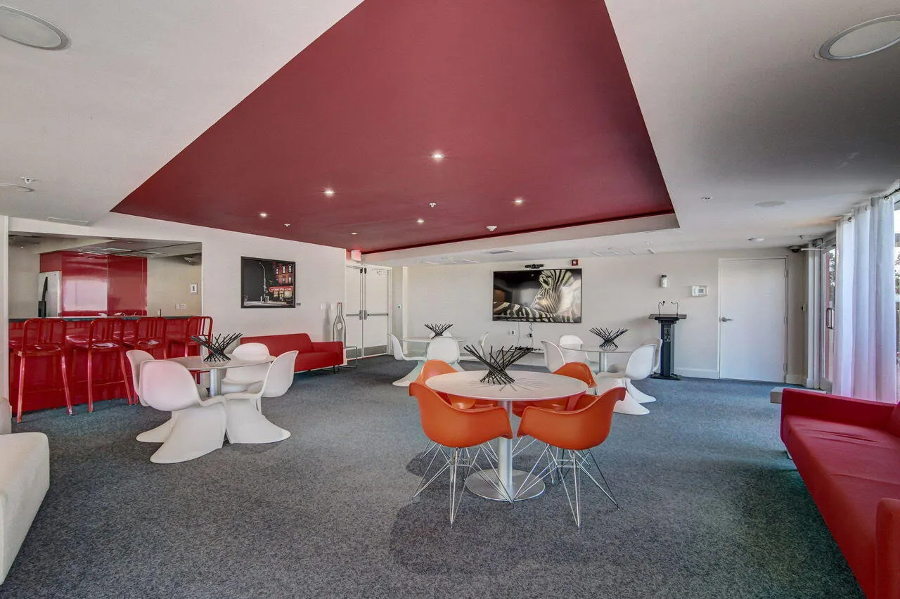 Spacious common area featuring recessed lighting, a red ceiling accent, and a built-in bar with seating