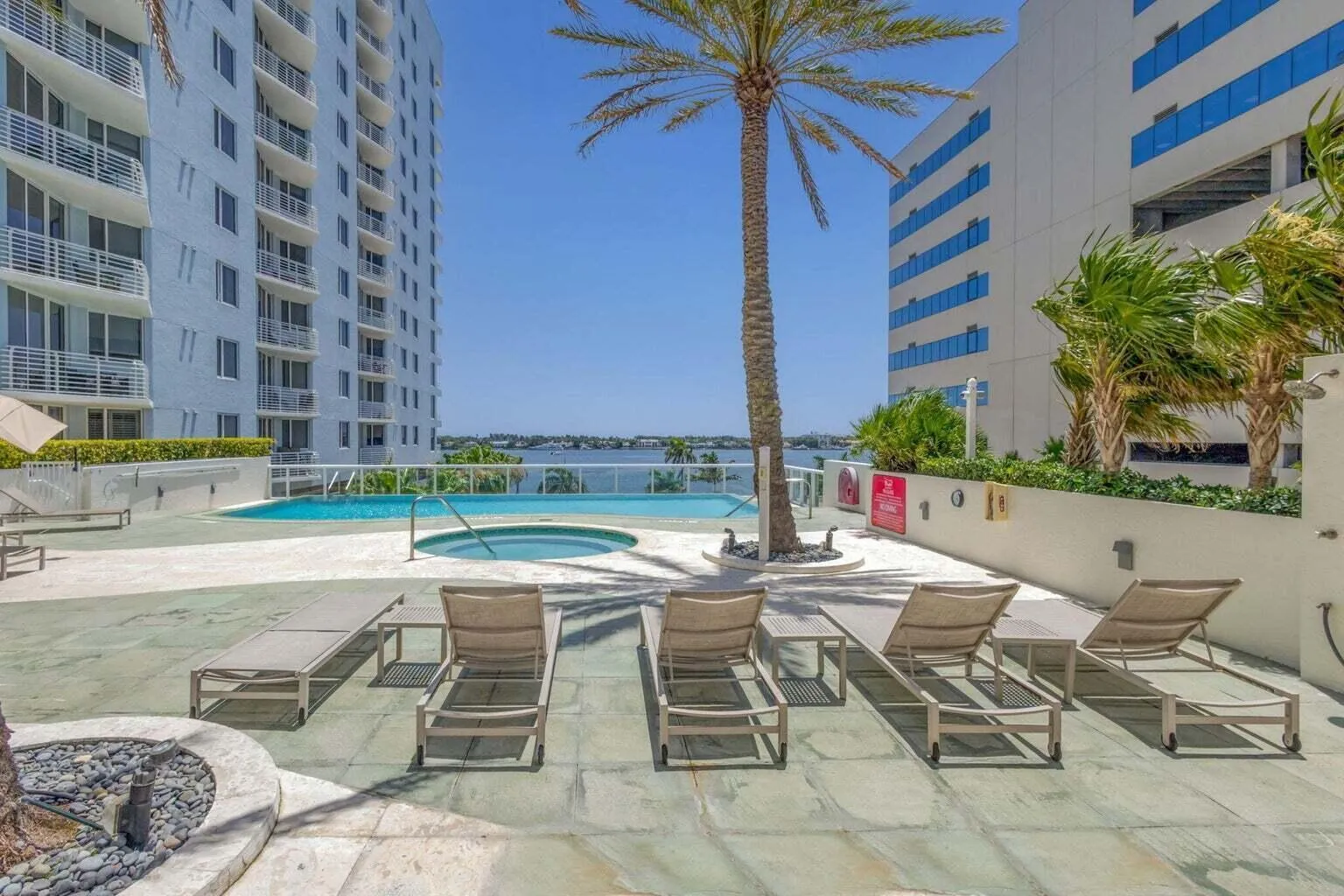 Expansive outdoor pool deck featuring a swimming pool, integrated spa, and several lounge chairs