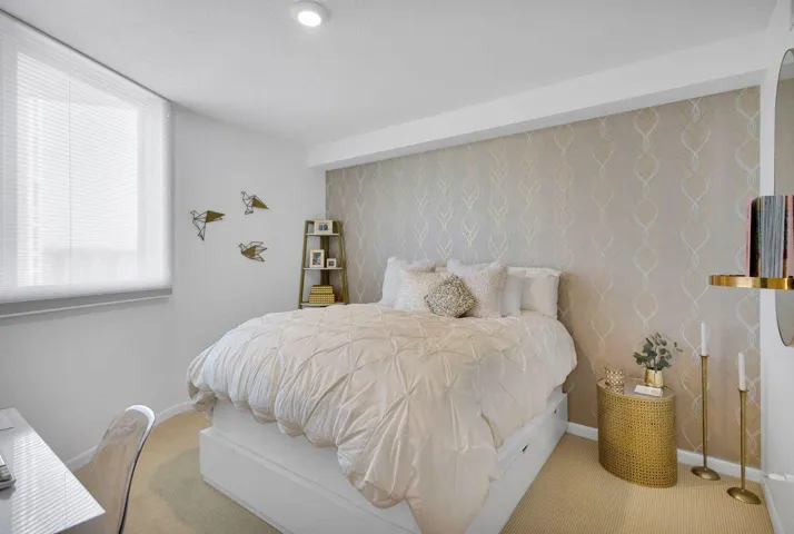 Bedroom featuring patterned accent wall, recessed lighting, window with horizontal blinds, and carpeted flooring