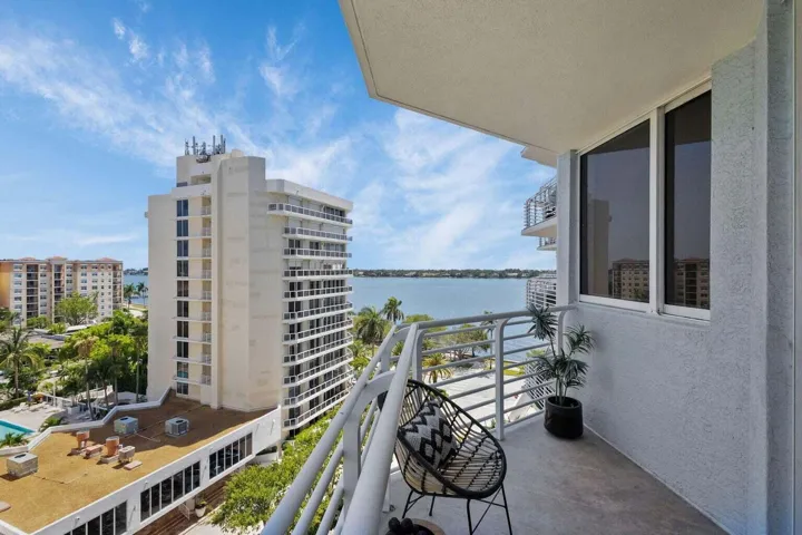 Private balcony featuring a concrete floor, white painted railing, and clear water scenery