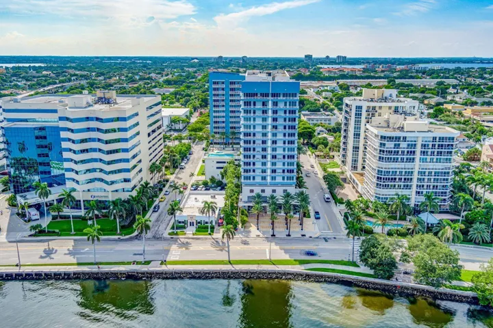 Aerial perspective showcasing a waterfront urban landscape with multiple high-rise buildings and surrounding green space