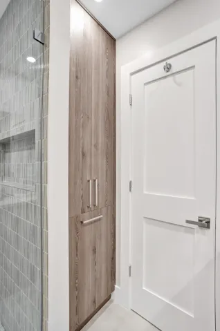 Custom pantry storage cabinet in hall bath with built in hamper