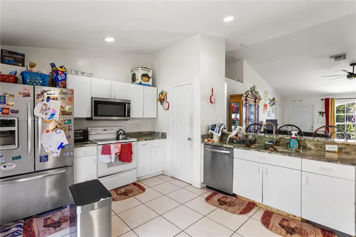 NEWER STAINLESS-STEEL APPLIANCES including a large refrigerator/freezer, microwave, and dishwasher
