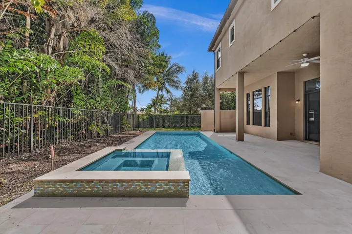 Modern outdoor living space featuring a resort-style saltwater pool with integrated spa, surrounded by expansive concrete decking