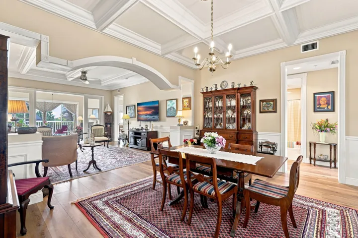 Notice the open floorplan, coffered ceilings, custom arch, and wide planked luxury vinyl flooring.