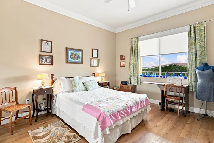 Second bedroom is spacious with luxury vinyl flooring, crown molding, and large closet. Water shut-off to condo is in this closet.