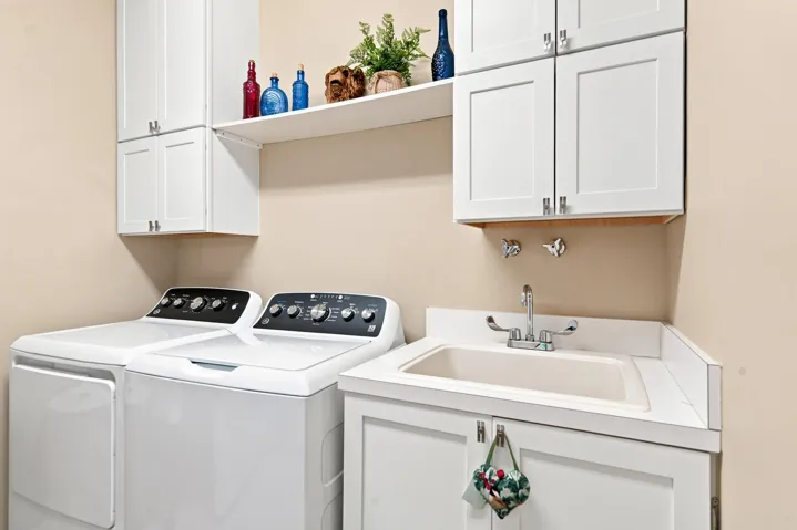 The laundry room has new cabinetry and a new washer/dryer.