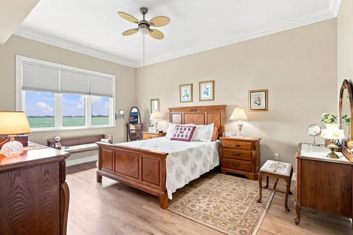 Primary bedroom also has beautiful water view. Notice the volume crown molding.