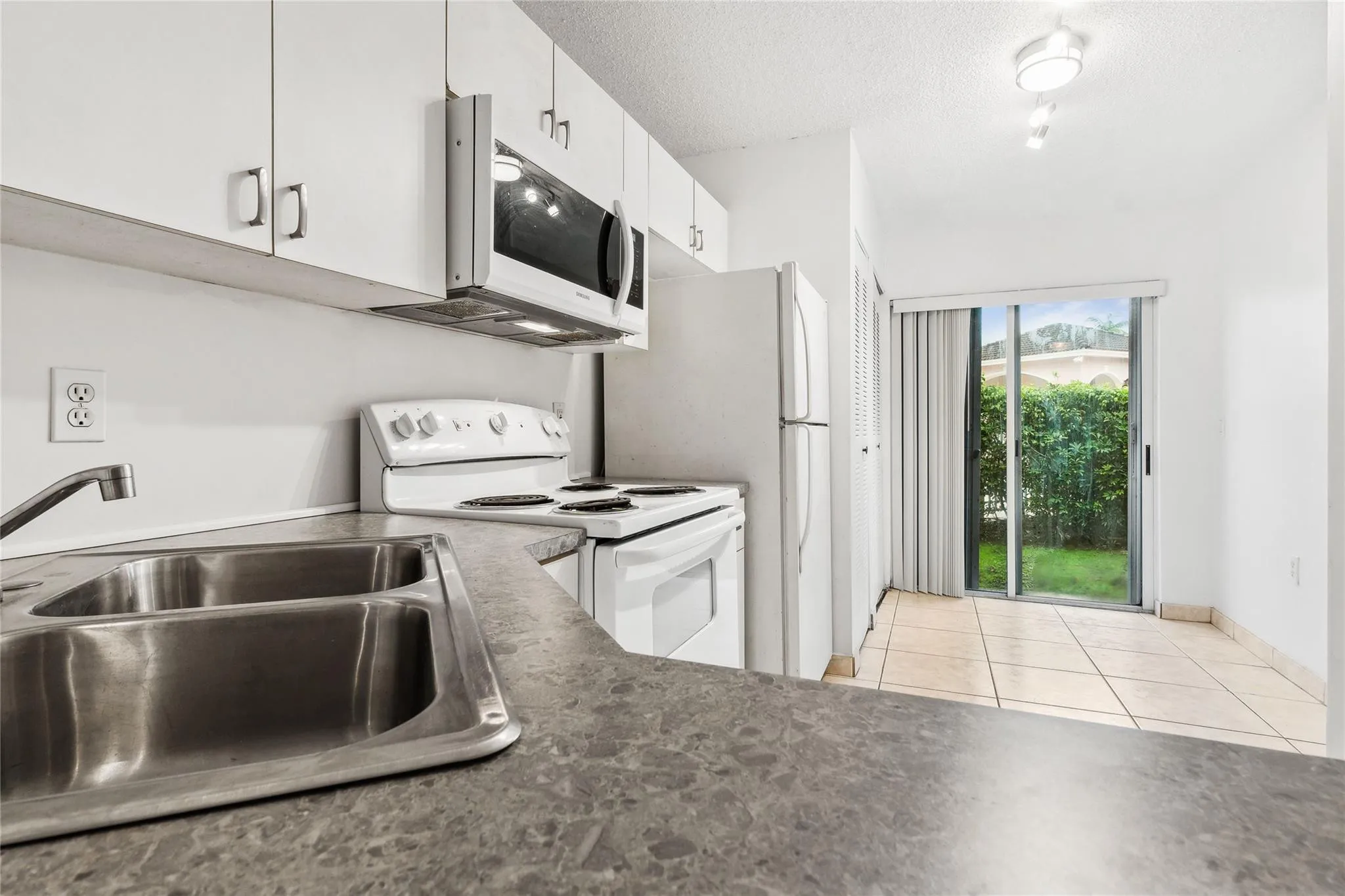 Kitchen leads to sliding doors small back yard
