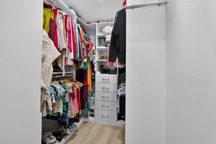 Custom closet system featuring multiple hanging rods, integrated shelving units, and built-in drawers