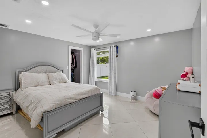 Bedroom featuring light gray walls, recessed lighting, and a ceiling fan