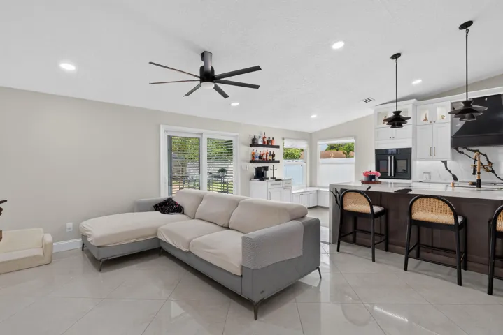 Open-concept living space featuring sleek tile flooring, a modern ceiling fan, and recessed lighting