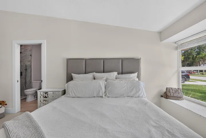 Neutral wall paint tones complement a large window with a built-in sill and a recessed window frame