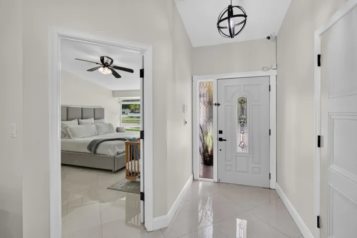 Entryway featuring a white paneled front door with decorative glass inserts and a sidelight