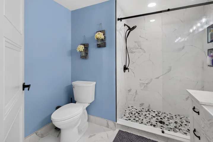 Shower enclosure featuring a sliding glass door and matte black fixtures
