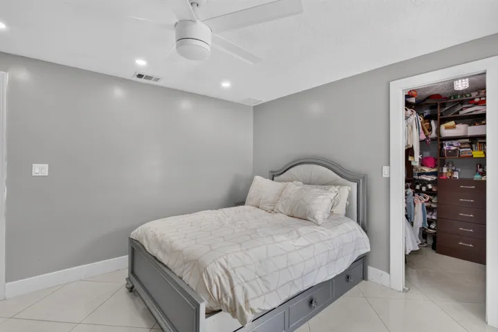 Bedroom featuring neutral gray walls, white baseboards, and light-toned tile flooring