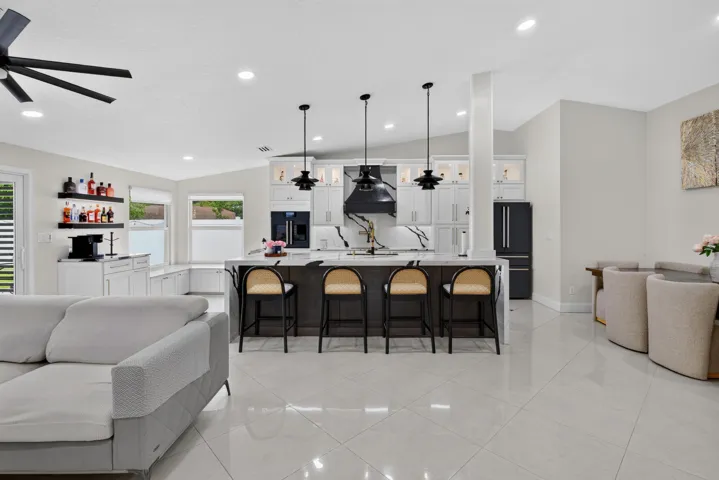 Spacious kitchen featuring a large island with seating, dark cabinetry, and white countertops