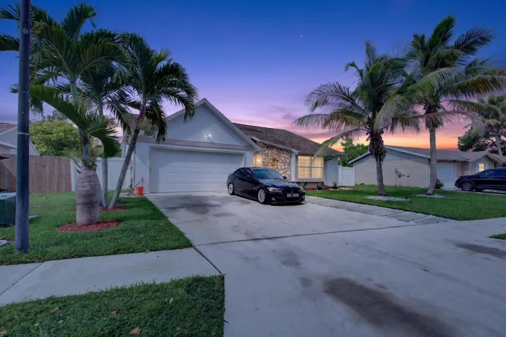 Single-story residence showcasing a two-car garage, concrete driveway, and manicured front lawn