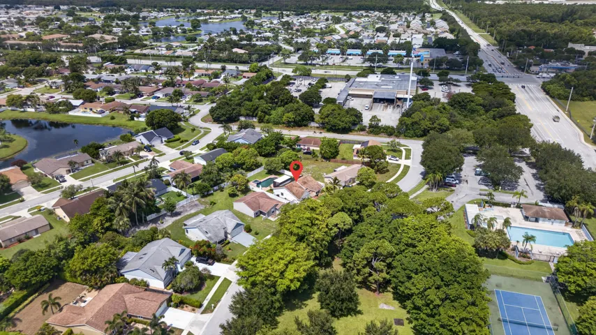 Aerial overview of a residential area featuring single-story homes with shingle roofs and green landscaping