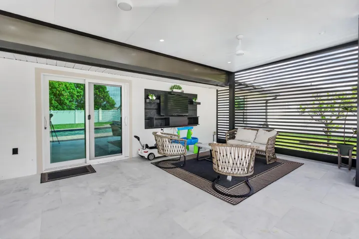 Covered outdoor living area with light-toned tile flooring