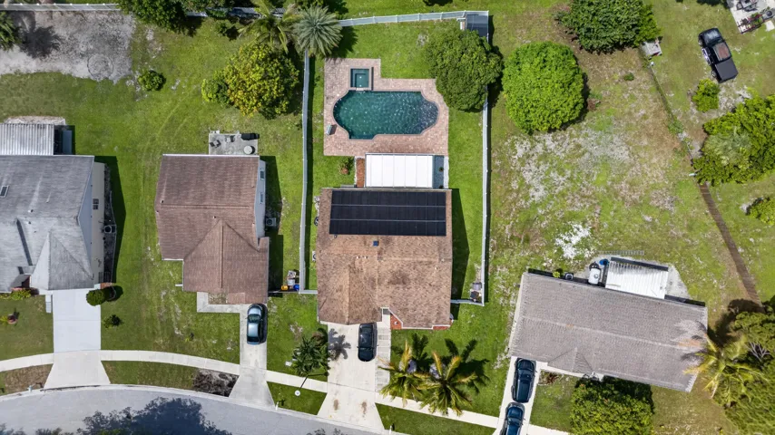 Aerial perspective showcasing a property with a fenced backyard featuring an in-ground swimming pool and spa