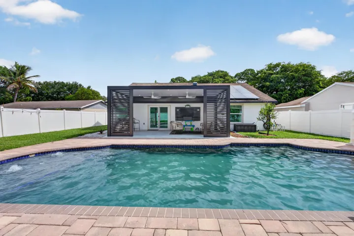 In-ground swimming pool with a brick paver surround