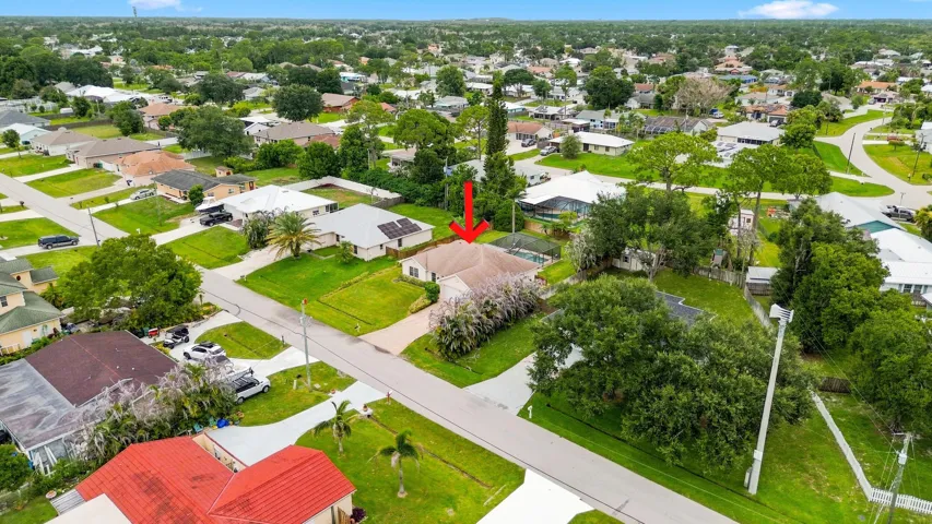 Single-story residence set on a corner lot with a pavered driveway and mature landscaping